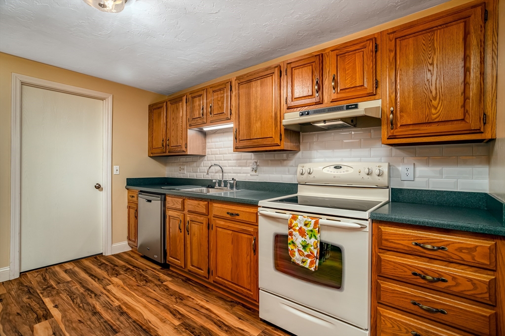115 Ridgefield Circle, Unit D Clinton, MA 01510 - Photo 11 of 29 a kitchen with stainless steel appliances granite countertop wooden cabinets and a stove top oven