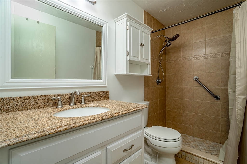 115 Ridgefield Circle, Unit D Clinton, MA 01510 - Photo 17 of 29 a bathroom with a granite countertop sink toilet and shower