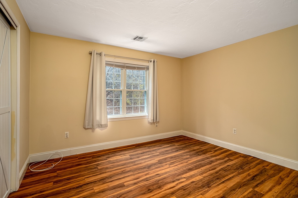 115 Ridgefield Circle, Unit D Clinton, MA 01510 - Photo 18 of 29 a view of empty room with wooden floor and fan