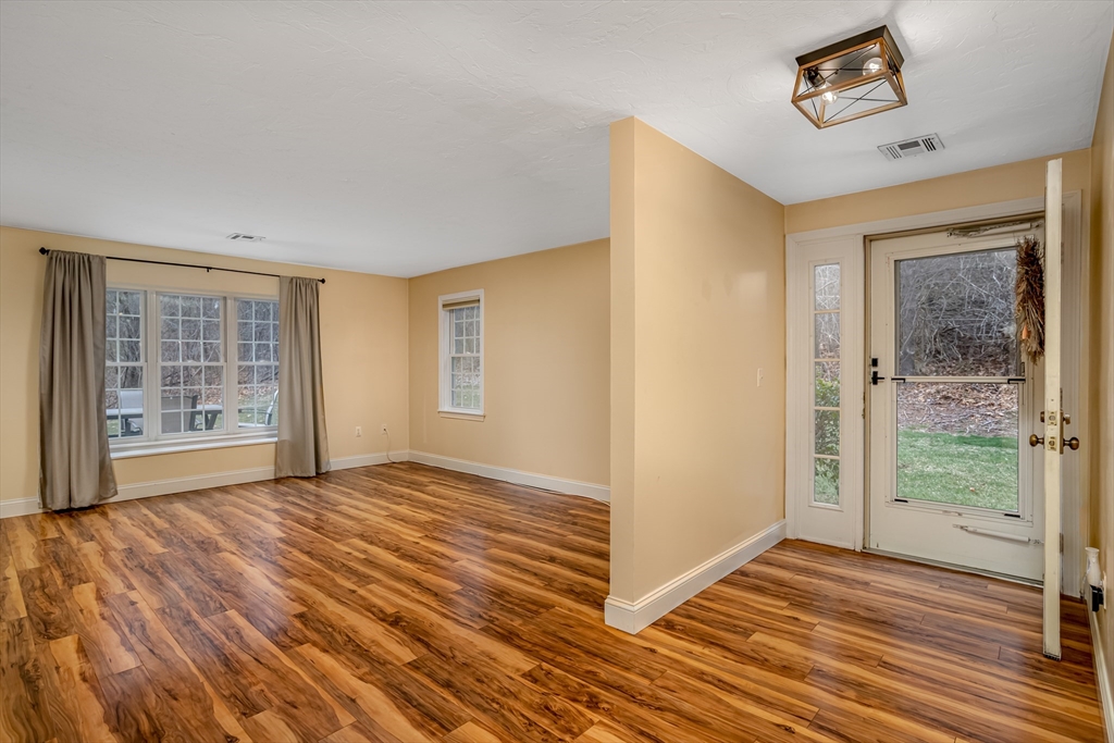 115 Ridgefield Circle, Unit D Clinton, MA 01510 - Photo 4 of 29 a view of an empty room with wooden floor and a window