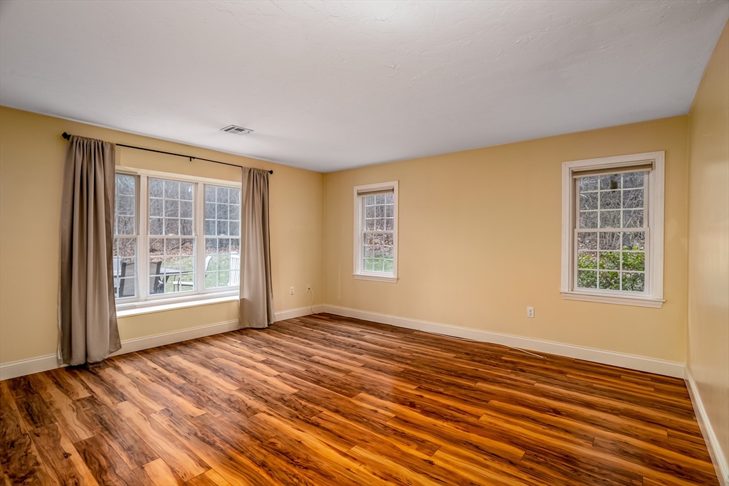 115 Ridgefield Circle, Unit D Clinton, MA 01510 - Photo 5 of 29 a view of an empty room with wooden floor and a window