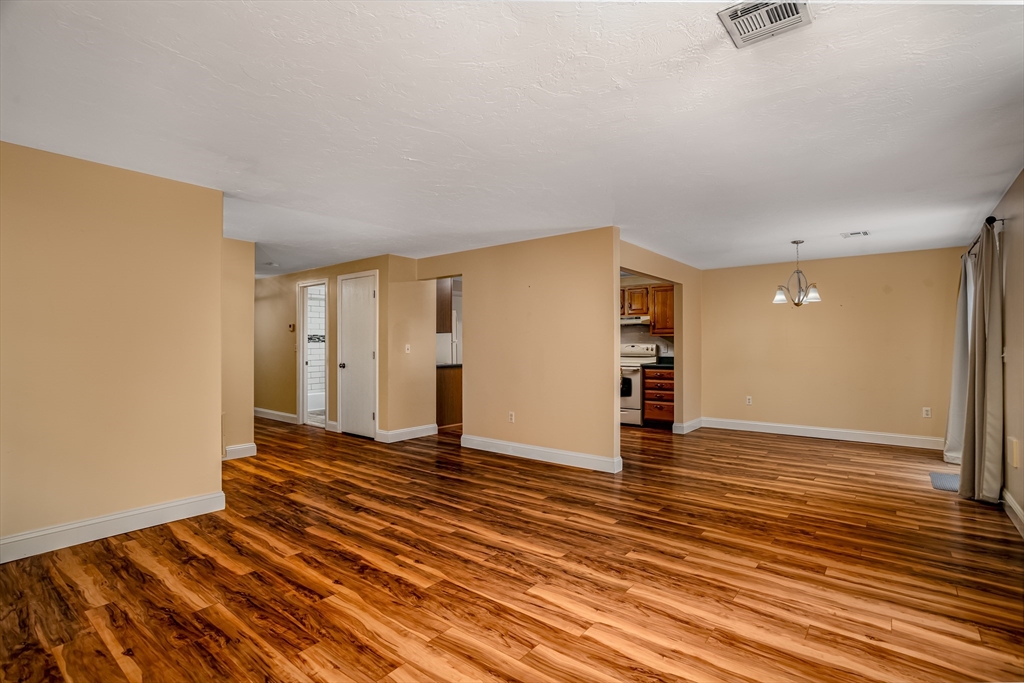 115 Ridgefield Circle, Unit D Clinton, MA 01510 - Photo 6 of 29 a view of an empty room with wooden floor and a window