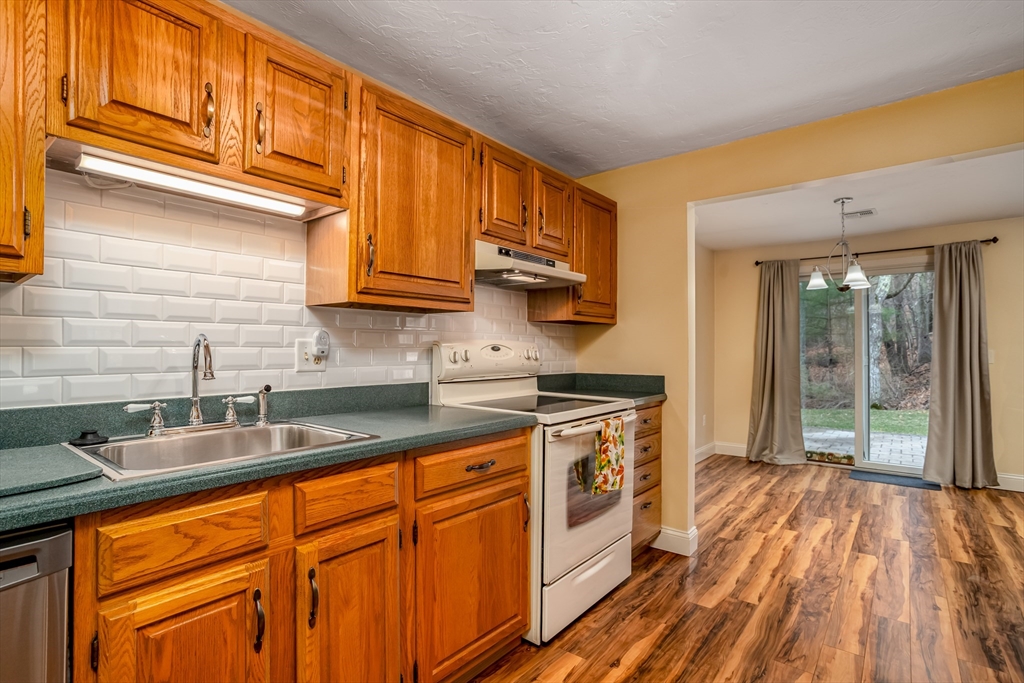 115 Ridgefield Circle, Unit D Clinton, MA 01510 - Photo 10 of 29 a kitchen with stainless steel appliances granite countertop a sink a stove cabinets and wooden floor