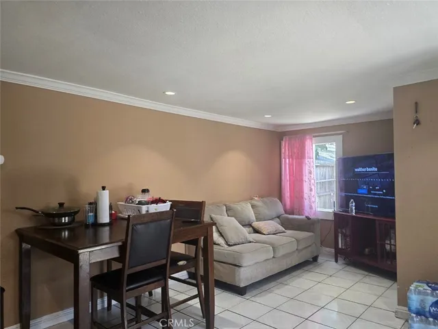 a living room with furniture a dining table and a refrigerator