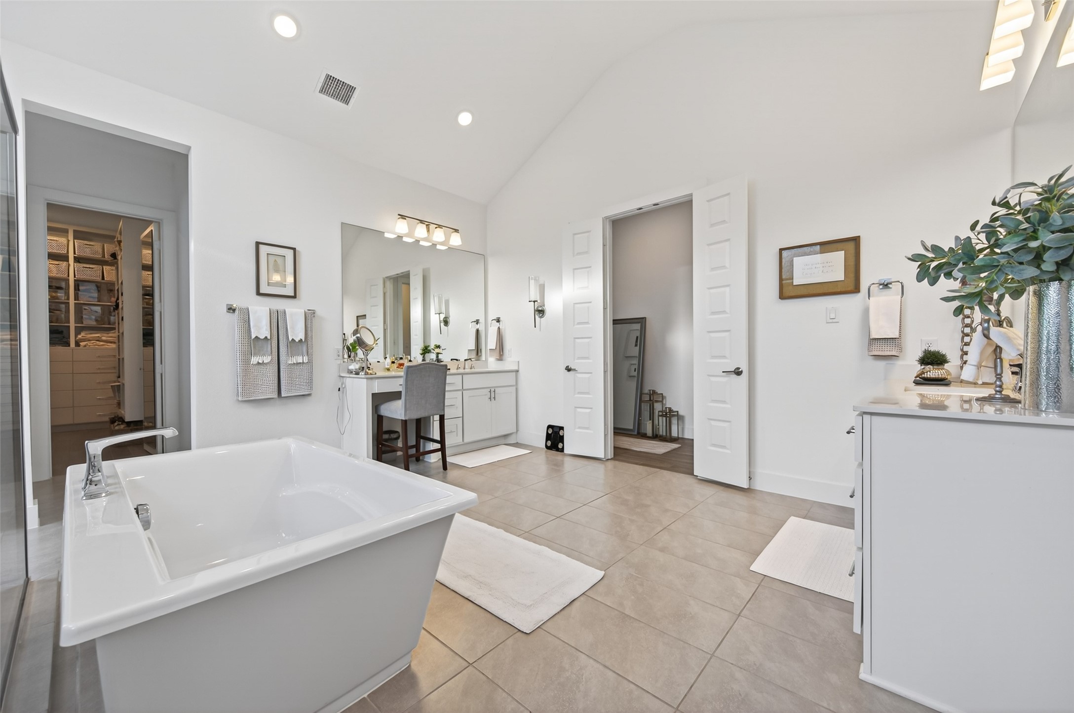 29612 Fulshear Lake Trace Fulshear, TX 77406 - Photo 36 of 48 This spacious bathroom features a freestanding bathtub, dual vanities with ample storage, and modern fixtures. It has a walk-in closet accessible from the bathroom and a neutral color scheme that enhances its bright, airy feel.