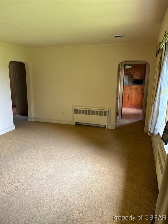 1956 Squirrel Level Road Petersburg, VA 23805 - Photo 4 of 12 Carpeted spare room featuring arched walkways and radiator