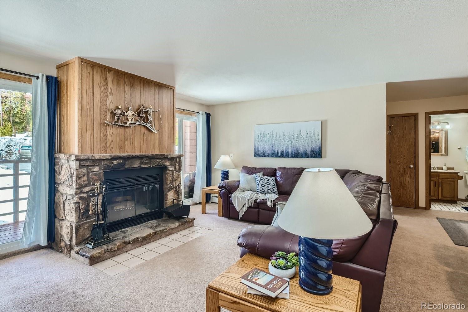 89100 Ryan Gulch Road, Unit 206 Silverthorne, CO 80498 - Photo 2 of 17 a living room with furniture and a fireplace
