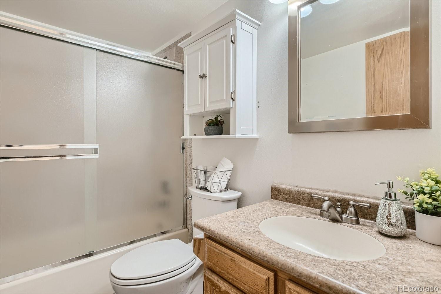 89100 Ryan Gulch Road, Unit 206 Silverthorne, CO 80498 - Photo 7 of 17 a bathroom with a granite countertop sink toilet a mirror and shower
