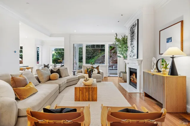 a living room with furniture a fireplace and a large window with wooden floor