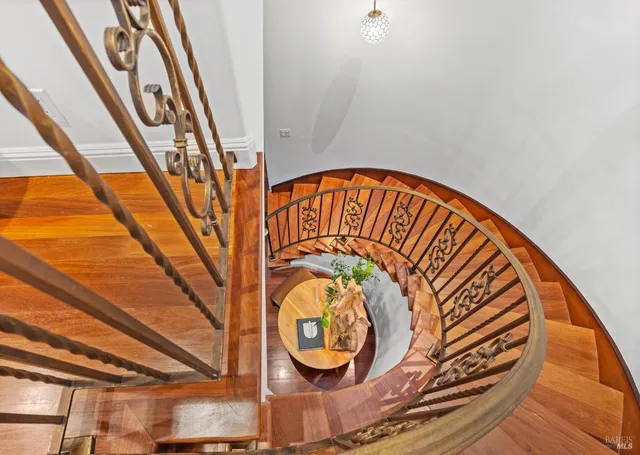 a view of a hallway with wooden floor and staircase