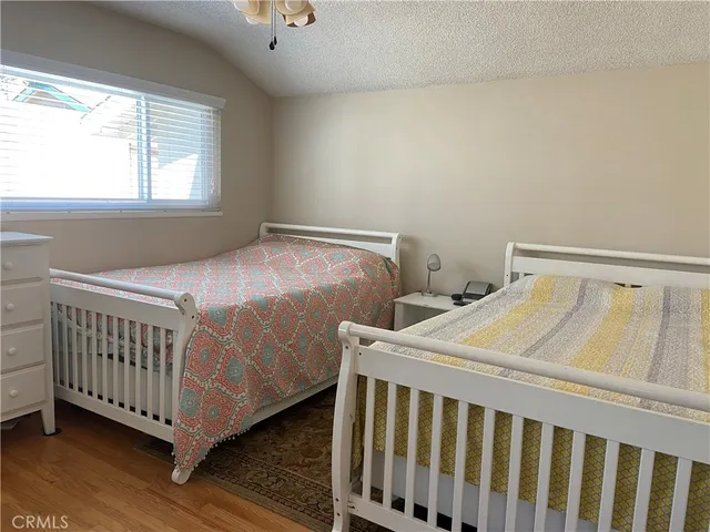 a bedroom with two beds and wooden floor