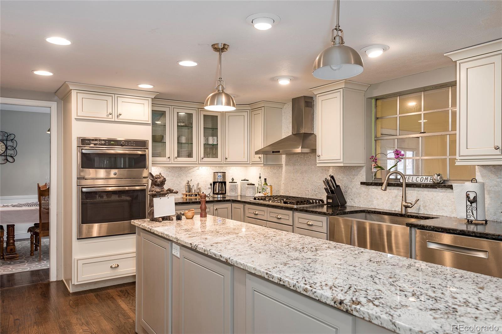a kitchen with stainless steel appliances granite countertop a sink counter space cabinets and wooden floor