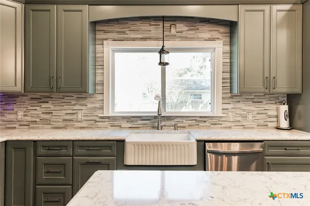 a kitchen with granite countertop a sink and a stove