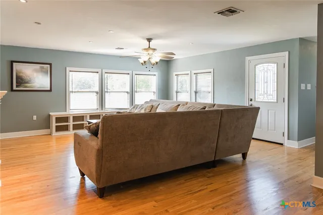 a living room with furniture and wooden floor