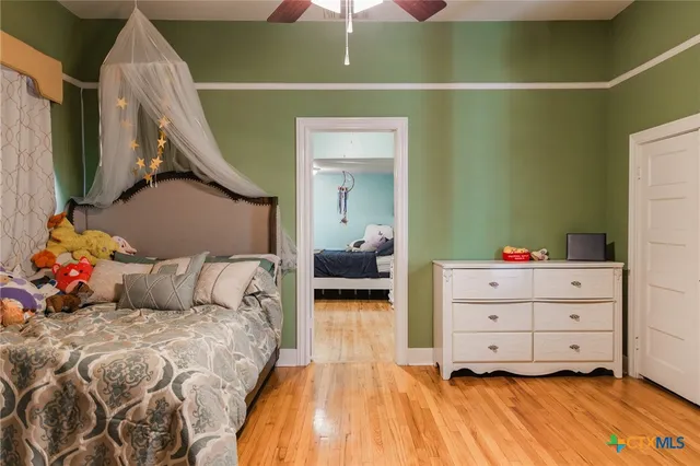 a bedroom with a bed and wooden floor