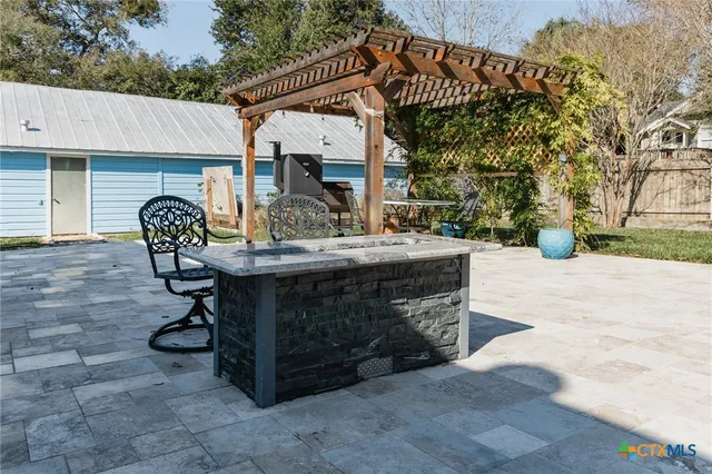 a view of a patio with table and chairs with wooden fence and plants