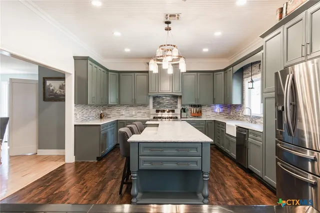 a large kitchen with a sink stainless steel appliances and cabinets