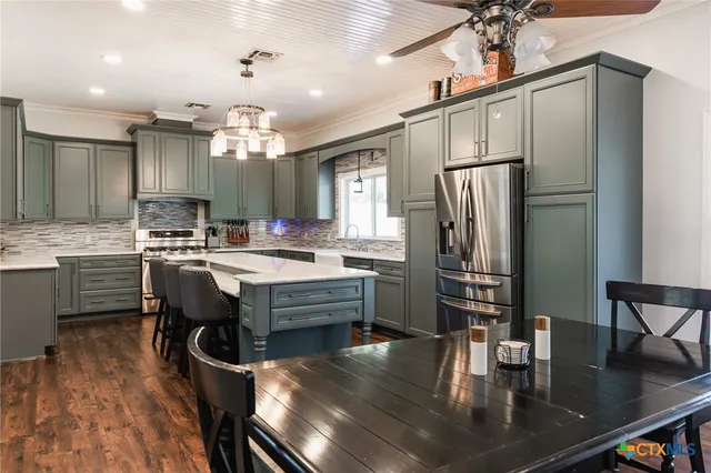 a kitchen with kitchen island a counter top space appliances and cabinets