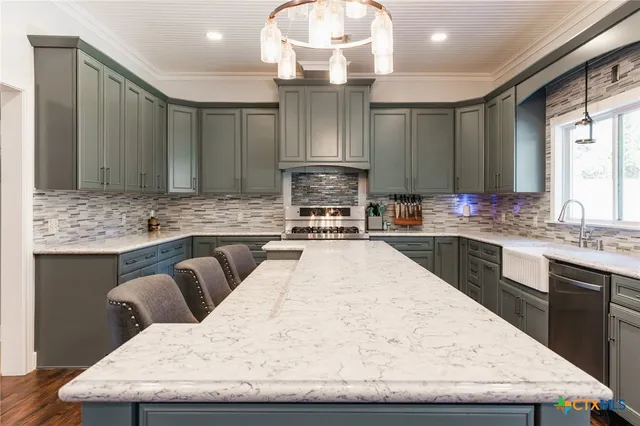 a large kitchen with granite countertop a sink stainless steel appliances and cabinets