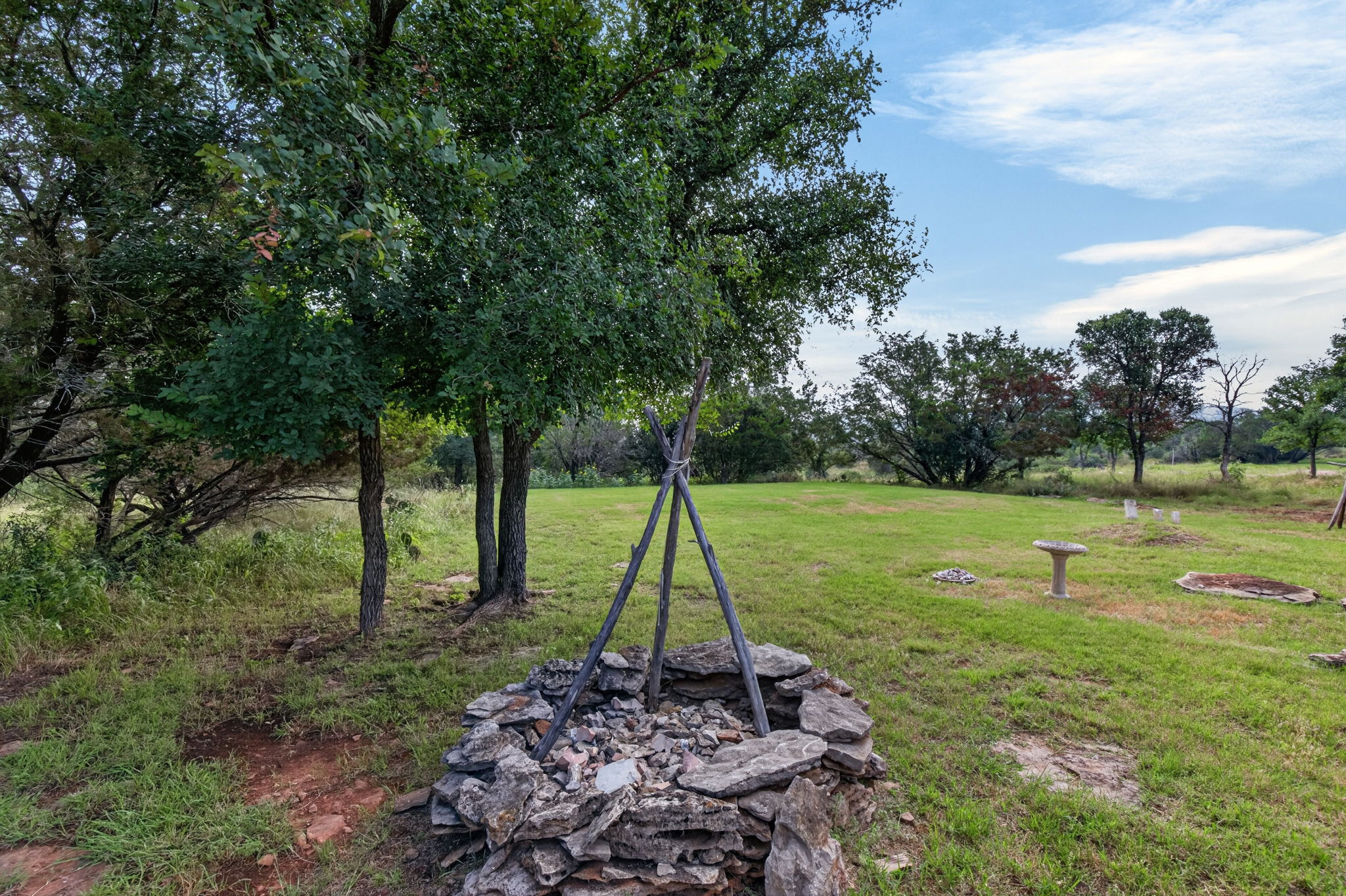 207 Deer Ridge Drive Burnet, TX 78611 - Photo 14 of 36 A spacious yard boasts a rustic fire pit, perfect for evening gatherings under open skies.
