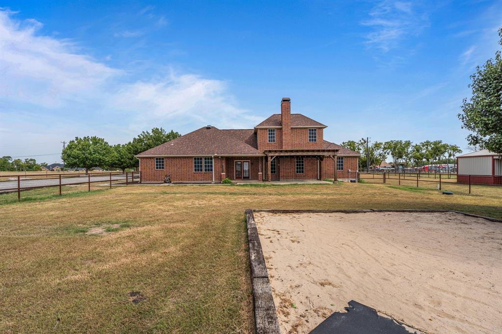 6501 Indian Trail Sanger, TX 76266 - Photo 28 of 39 Back of house with a chimney, a fenced backyard, brick siding, and a shingled roof