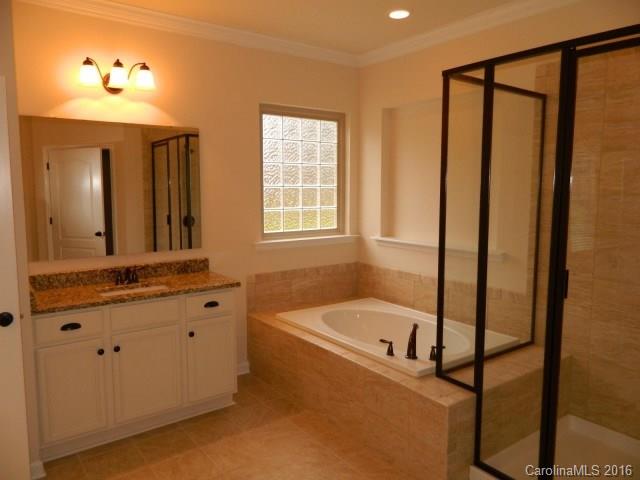 5202 Waterloo Drive, Unit CC174 Tega Cay, SC 29708 - Photo 14 of 15 a bathroom with a tub sink and mirror