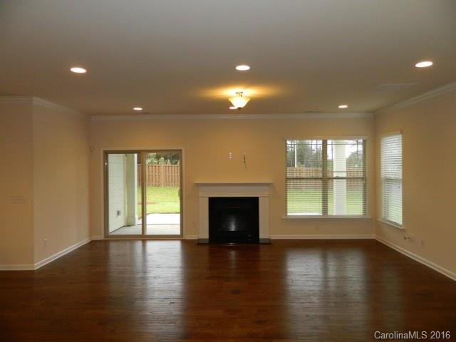 5202 Waterloo Drive, Unit CC174 Tega Cay, SC 29708 - Photo 7 of 15 an empty room with wooden floor and fireplace