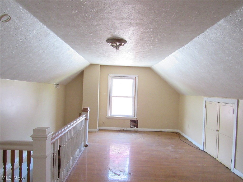 1726 Lee Road Cleveland Heights, OH 44118 - Photo 32 of 36 Attic space featuring wood-finish flooring, a double-hung window, built-in closet, and a ceiling-mounted light fixture