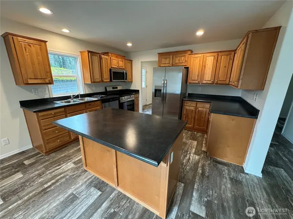 a kitchen with stainless steel appliances granite countertop a stove a sink and a refrigerator