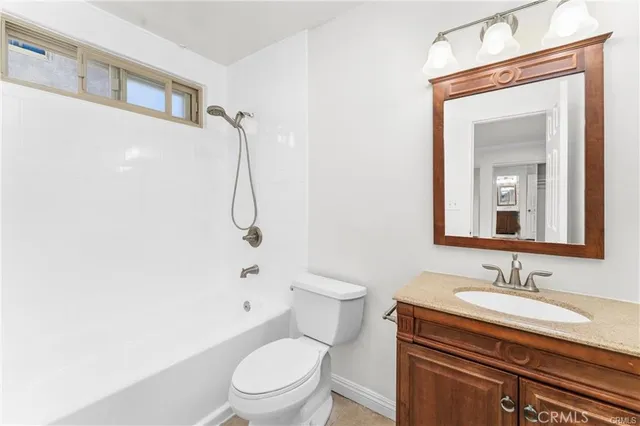 a bathroom with a granite countertop sink a toilet and shower