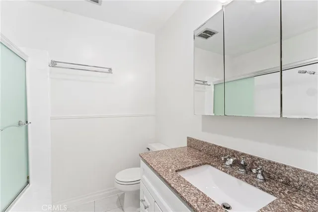 a bathroom with a granite countertop sink toilet and shower