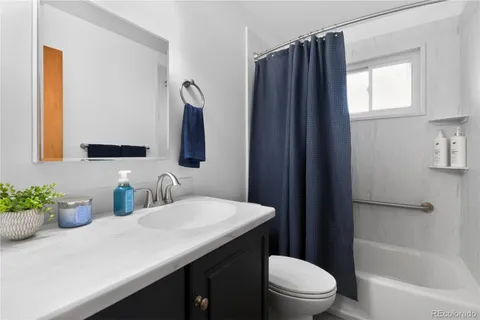 a bathroom with a sink a toilet a mirror and shower