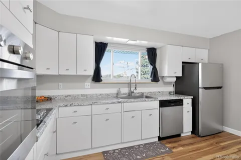 a kitchen with a sink dishwasher a refrigerator and cabinets