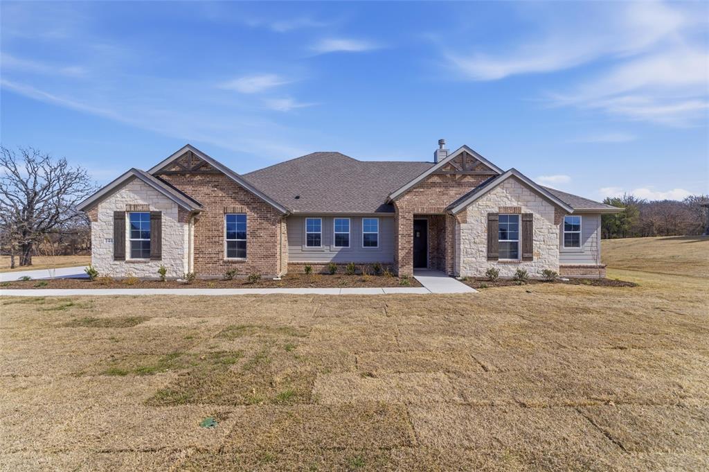 144 Oak Grv Way Springtown, TX 76082 - Photo 2 of 27 a front view of house with yard and trees in the background