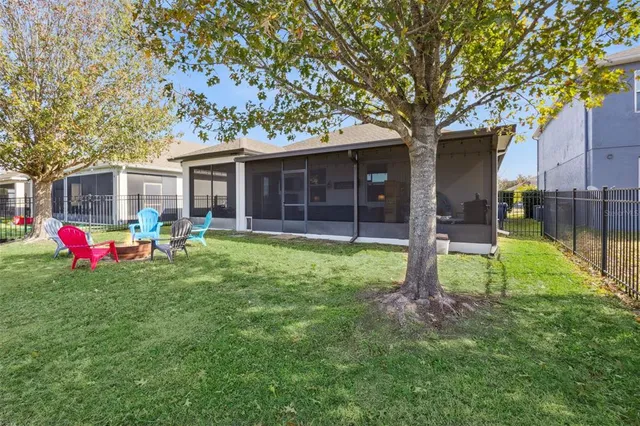 a view of a patio with table and chairs under an umbrella with large trees
