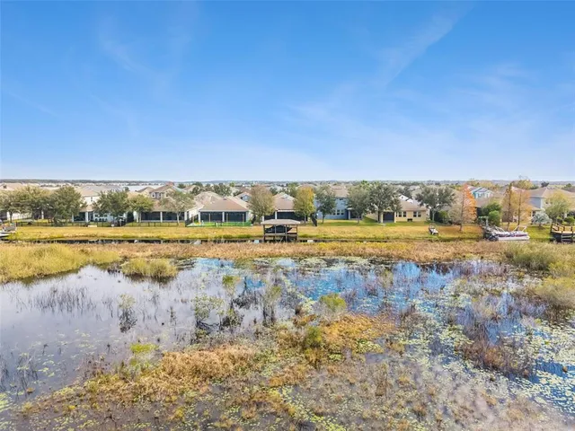 a view of a swimming pool with lawn chairs under an umbrella