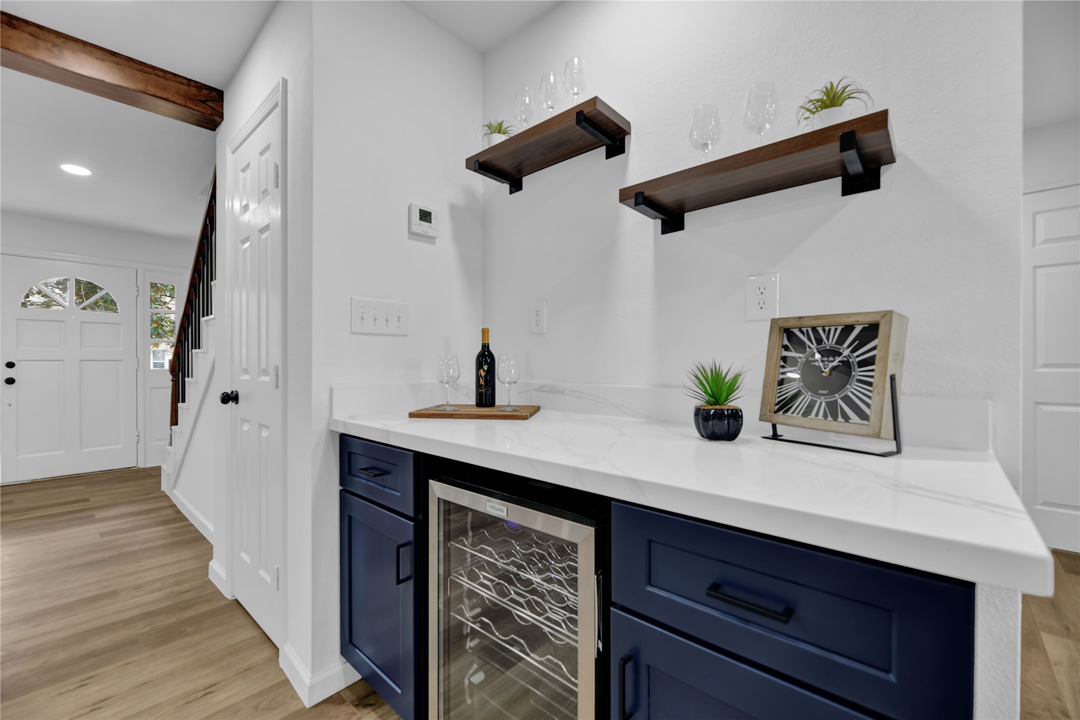 2726 Stetson Lane Houston, TX 77043 - Photo 12 of 36 Stylish dry bar with extended counter space, wine fridge, storage, and floating shelves a seamless and functional extension of the kitchen.