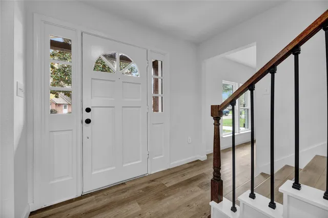 a view of an entryway with wooden floor and door