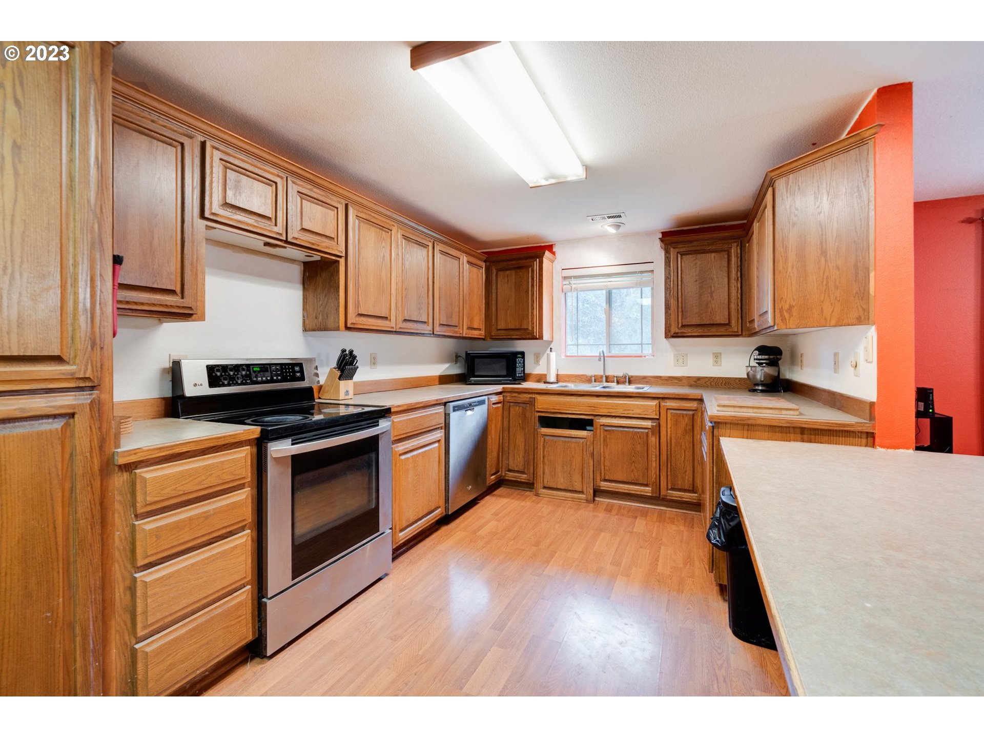 17802 Northeast 219th Street Battle Ground, WA 98604 - Photo 11 of 42 a kitchen with granite countertop wooden floors stainless steel appliances and a window