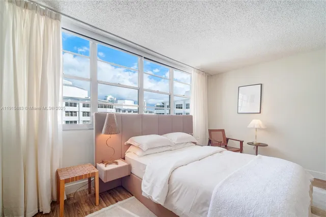 a bedroom with a bed and a large window