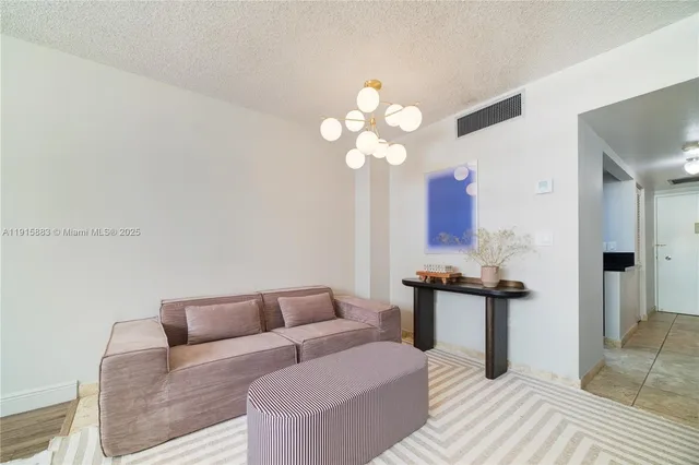 a living room with furniture a chandelier and a wooden floor