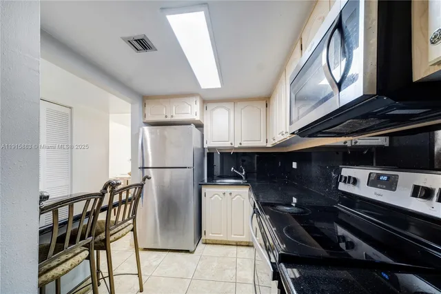 a kitchen with stainless steel appliances granite countertop a stove a refrigerator and a microwave