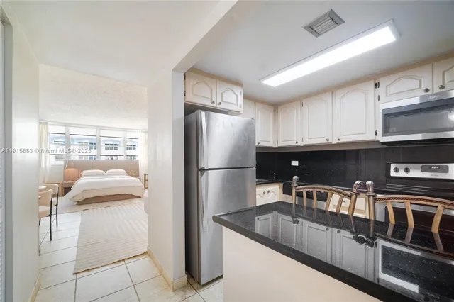 a kitchen with stainless steel appliances granite countertop a refrigerator and a stove