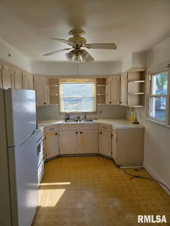 a kitchen with a sink cabinets stainless steel appliances and a window