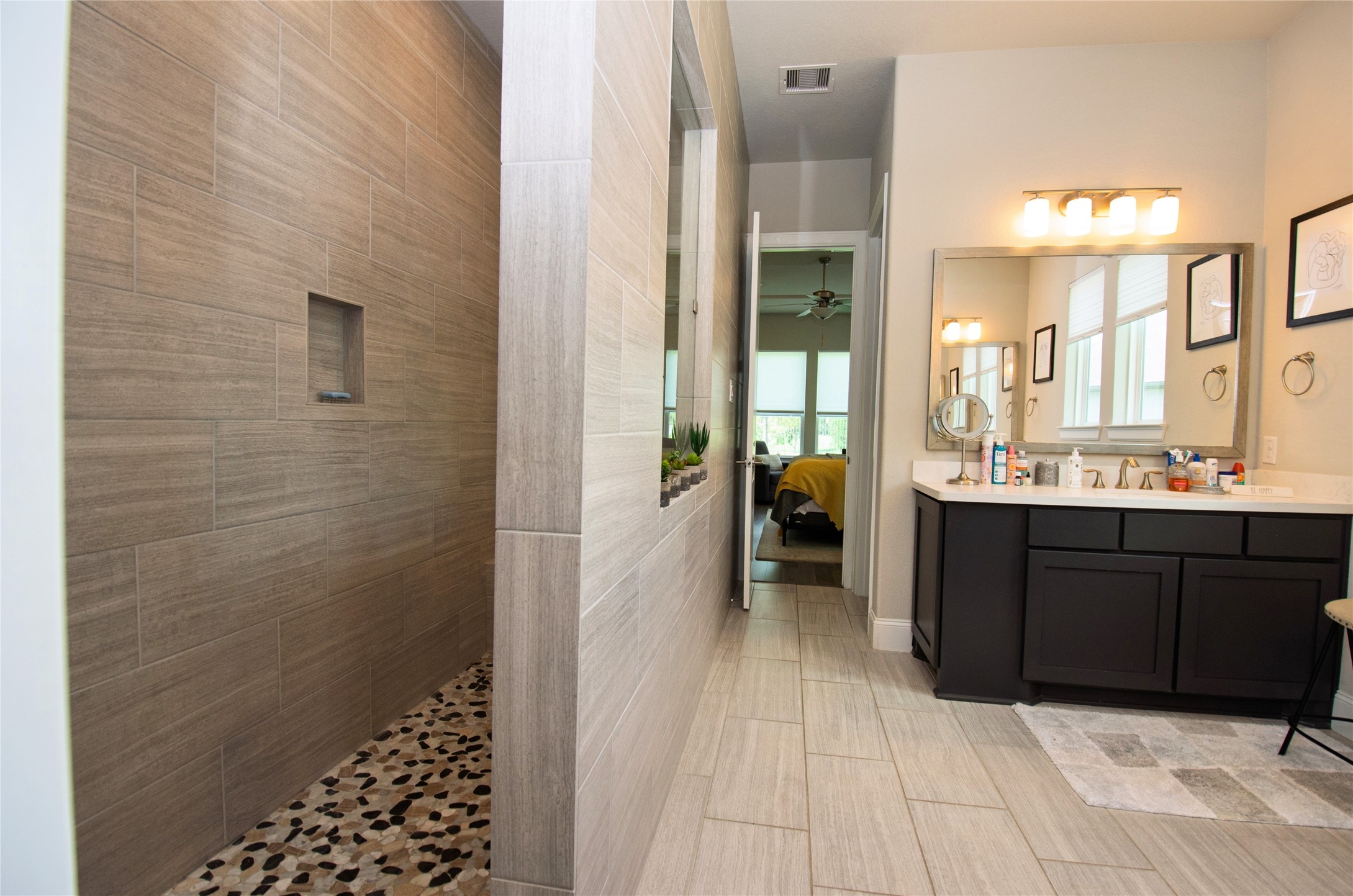 4143 Shackleton Court Iowa Colony, TX 77583 - Photo 16 of 34 The primary bathroom features a spacious walk-in shower with elegant tile work and pebble flooring. It also includes a double vanities.