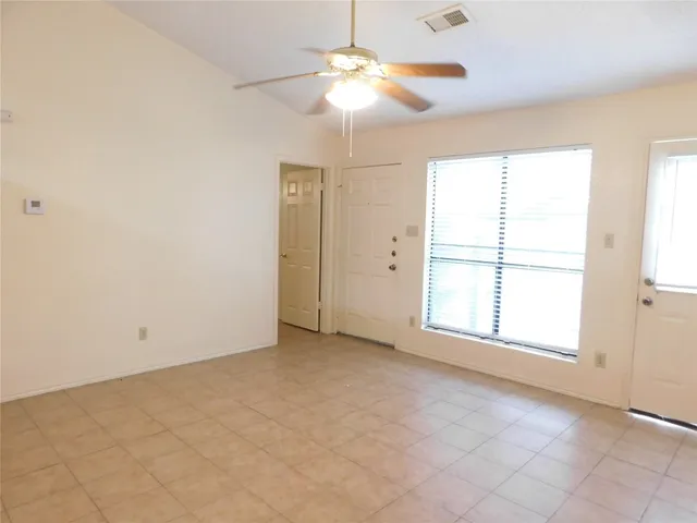 an empty room with chandelier fan