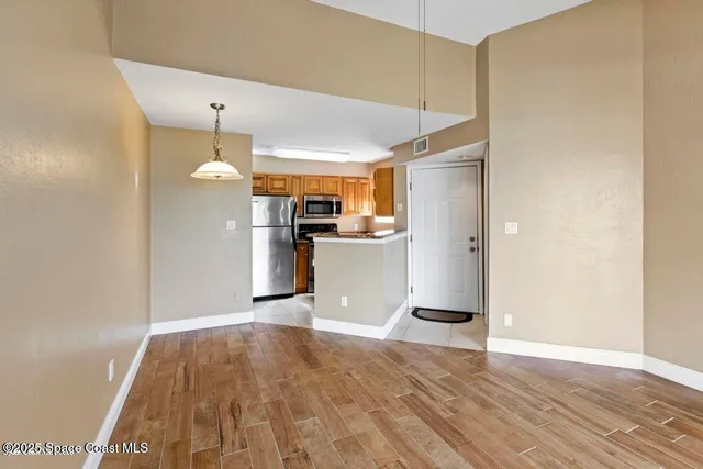 a kitchen with a refrigerator and a wooden floor