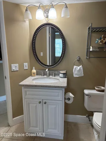 a bathroom with a sink mirror vanity and toilet