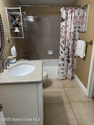 a bathroom with a granite countertop sink a mirror and shower