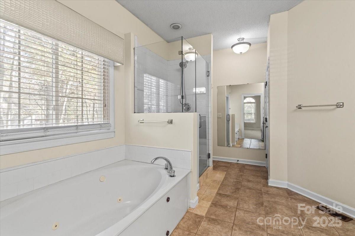 5619 Weddington Road Concord, NC 28027 - Photo 23 of 48 a bathroom with a bathtub shower and toilet